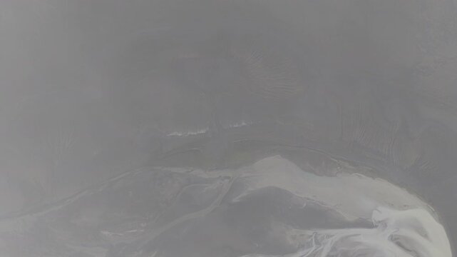 Aerial view of the stark, muted landscape where rivers carve through the terrain, creating abstract patterns in the Landmannalaugar area, Rangarthing ytra, Iceland.