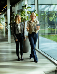 Two professionals walking and discussing ideas in a modern office space during the day