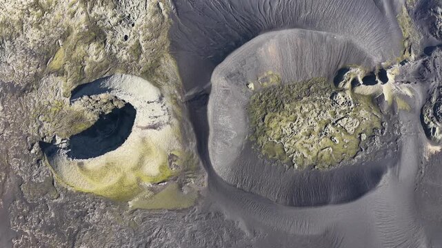 Aerial view of the dark, volcanic Laki craters, where mossy green vegetation dots the landscape, creating a stark contrast, Laki volcano, Skaftarhreppur, Iceland.