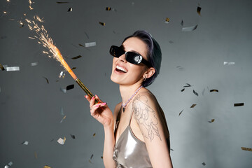 Young woman celebrating with sparkles in stylish attire and joyful expression