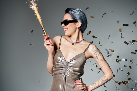 Stylish woman celebrating with sparkler in trendy attire at a festive gathering