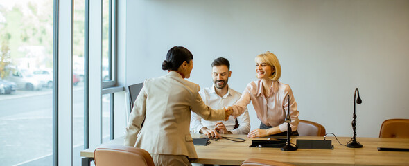 Business meeting with handshake between colleagues in a modern office