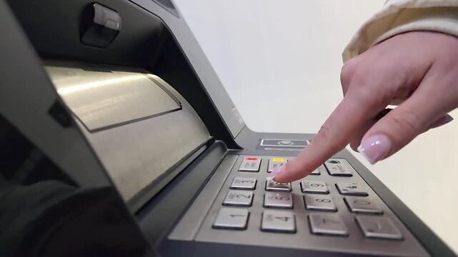 Woman entering PIN code on ATM keypad during banking transaction. Close-up of finger pressing numeric buttons on automated teller machine, concept of financial security, banking access and digital pay