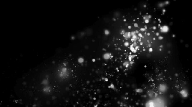 A monochrome image showing a cluster of blurred white dots against a black background in the corner