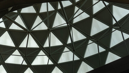 Close-up view of a geometric glass dome with triangular panels and steel framework creating a modern architectural pattern.