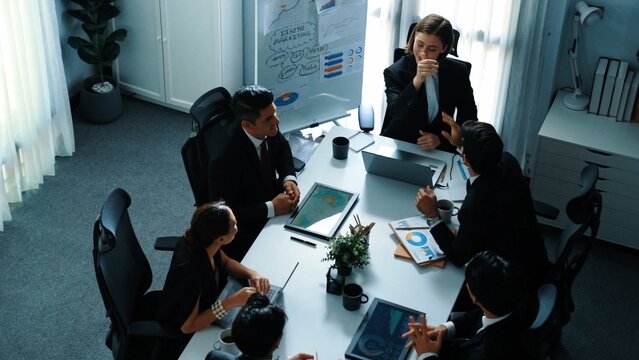 Top view of smart executive manager looking at financial graph while skilled business team give high five and clapping hands to celebrate increasing sales. Successful team shaking hands. Directorate.