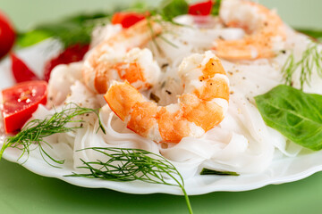 Culinary presentation of boiled rice noodles with shrimp and vegetables