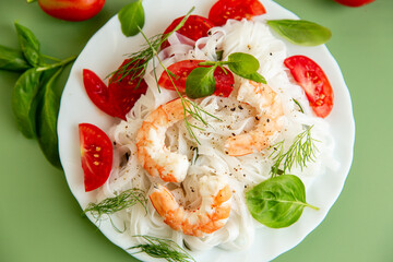 Gourmet still life of white rice pasta shrimp tomatoes and greens