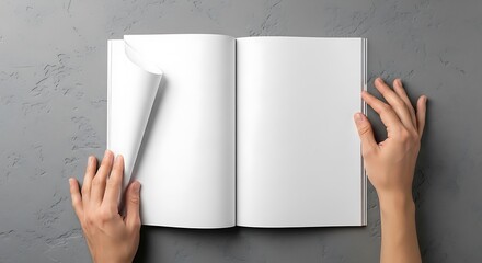 Top view of hands turning a blank page in an open book or magazine with empty white pages, ready for design, on a grey background