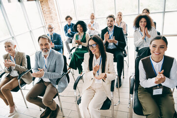 Business professionals applauding during a corporate meeting in an office environment, demonstrating teamwork and collaboration