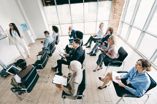 Business professionals attending a corporate training session in a modern office conference room with large windows