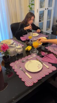 M&atilde;e e filha tomando caf&eacute; da manha juntas em casa 