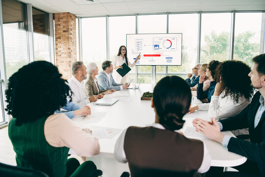 Group of professionals participating in a business meeting room, showcasing teamwork and collaboration during a presentation - Powered by Adobe