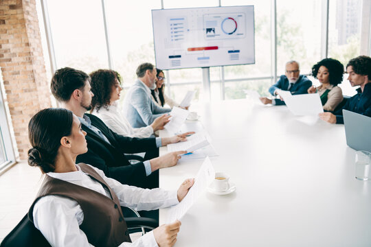 Professional team in business meeting reviewing documents in a modern office setting during collaborative teamwork