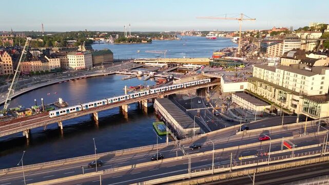 Stockholm, Sweden - 27 July 2025: Aerial view of the Slussen area showing waterway traffic, construction, and buildings under a clear sky.