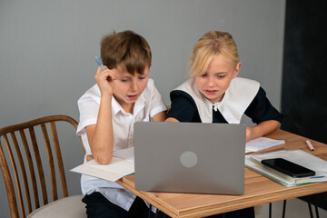 Children Laptop Online Learning Home Schooling: Boy and girl studying at home with a laptop.