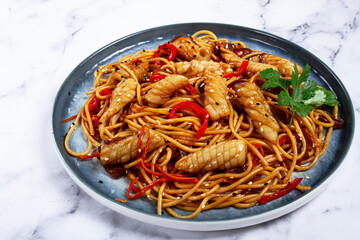 udon noodles, with squid and vegetables, on a marble table, homemade, no people,