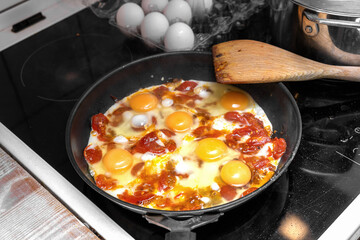 Rustic eggs with tomatoes cooking