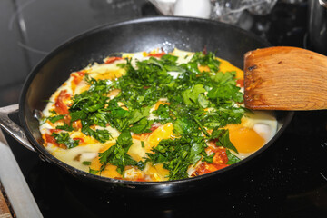Homemade eggs with tomatoes in pan.