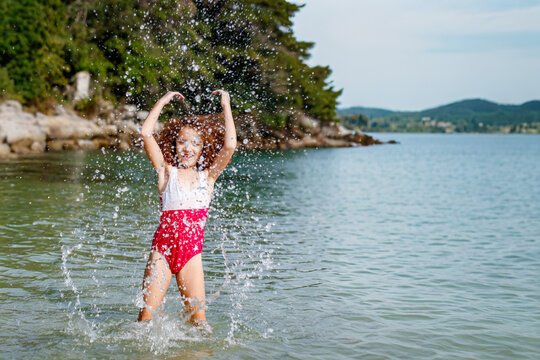 Red-haired girl playing in the water on a beach on the Brazilian coast, in the city of Bombinhas, Santa Catarina.
