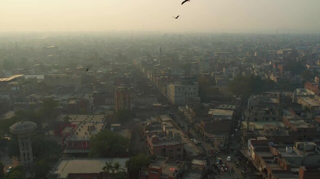 Lahore, Pakistan - 29 July 2025: Aerial view of Data Darbar Road's bustling streets, a vibrant mix of buildings under a hazy sky, captured from above.