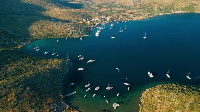 Aerial view of boats floating on the serene blue waters of Cokertme Bay, a beautiful contrast to the mountainous landscape, Cokertme, Mugla, Turkiye.
