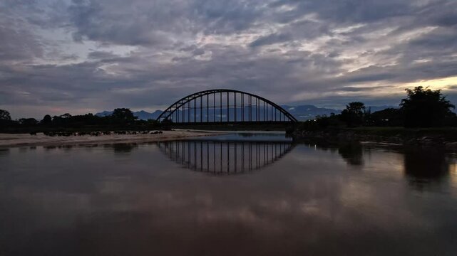 Puente con reflejo en el agua en el atardecer - 4k