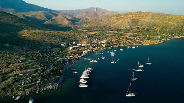 Aerial view of boats in Cokertme Bay, where white yachts contrast with the deep blue sea, set against a backdrop of sun-kissed hills, Cokertme, Mugla, Turkiye.