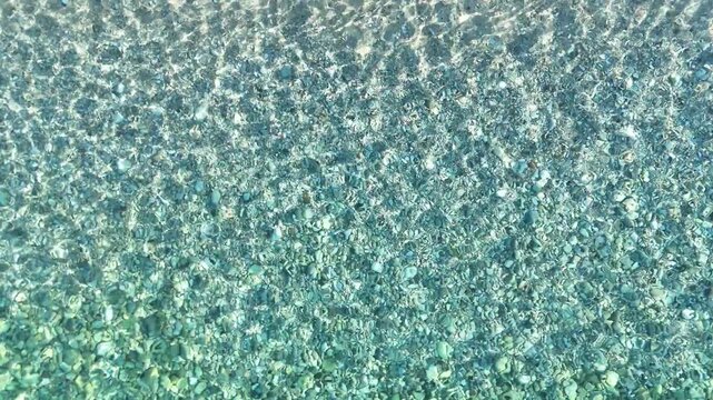 Ripple on the water with reflection of sunlight in the Adriatic Sea near the beach in the city of Himara in Albania