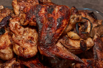 Juicy pieces of chicken were grilled in a metal grill over hot coals. The ruddy crust and smoky aroma emphasize the atmosphere of a picnic and a summer vacation in nature.