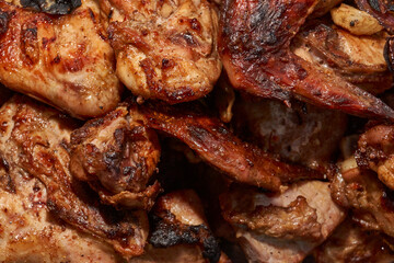 Juicy pieces of chicken were grilled in a metal grill over hot coals. The ruddy crust and smoky aroma emphasize the atmosphere of a picnic and a summer vacation in nature.