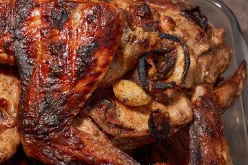 Juicy pieces of chicken were grilled in a metal grill over hot coals. The ruddy crust and smoky aroma emphasize the atmosphere of a picnic and a summer vacation in nature.