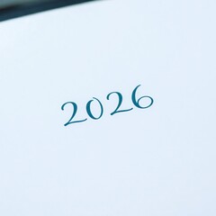 Pale page with teal calligraphic 2026 positioned slightly above center, tilted gently upward to the right