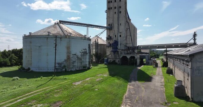 Cincinnati, United States - 02 August 2025: Aerial view of weathered grain silos, their surfaces stained and aged, connected by rusted metal walkways and a tall elevator.