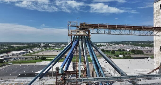 Cincinnati, United States - 02 August 2025: Aerial view of a weathered industrial building with blue structural supports under a partly cloudy sky.