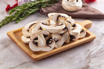 Raw champignon slices on the board