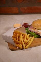 🏷️ Título SEO (exactamente 200 caracteres):
Hamburguesa artesanal casera con papas fritas, kétchup y salsa de ajo en copetín tradicional – comida rápida gourmet, fotografía de comida, rustica