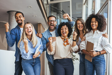 Diverse Team Celebrates Achievement In Modern Office Corridor With Cheerful Friendship And Energy