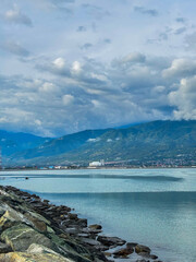 Serene coastal view in palu city featuring calming blue waters and majestic mountains in the distance perfect for travel campaigns