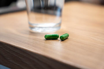 Green Medicine Capsules on Wooden Table