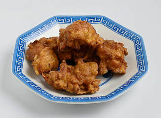 Golden fried chicken pieces on a blue and white plate. Perfect for restaurant menus, food blogs, and culinary projects