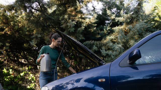 Woman pouring engine oil, car maintenance outdoors