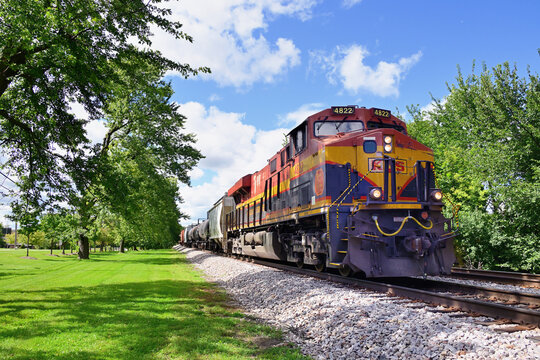 A Kansas City Southern locomoitve leads a Canadian Pacific Kansas City merchandise freight train eastbound through northeastern Illinois.