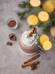 Hot chocolate with wipped cream in a cup on a light background with spices
