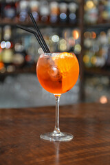 Closeup glass of spritz aperol cocktail decorated with orange at bright bar counter background.