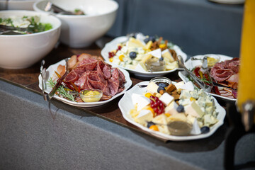 A variety of fresh dishes displayed on a buffet table at a catered event, featuring salads, appetizers, and hot meals arranged in a professional food service setup