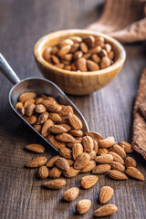 Almond kernel nuts on scoop on wooden table.