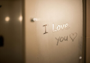 "I Love You" Handwritten on a Steamy Bathroom Mirror with a Heart Drawn Next to it