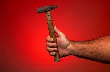 A man holding a hammer in his hand. Man holding an old hammer. Hammer with a wooden handle tool