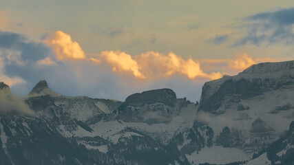 Sunlit winter mountains with dramatic clouds